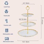 Elegant BPFY 3-tier porcelain serving tray with gold trim and embossed floral design, holding cupcakes and pastries.