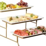 Three-tier serving set with white rectangular plates and a gold metal stand, displaying various snacks.