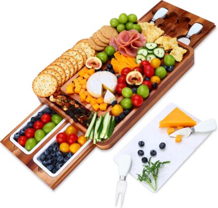 A large hecef acacia wood charcuterie board set with cheese, crackers, and fruit, showing the pull-out drawers and knife set.